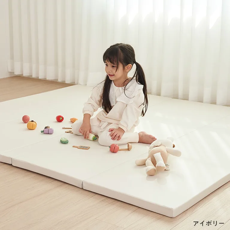 アイボリーのpopomi抗菌プレイマットCLEANを室内に敷き、子どもがおもちゃで遊ぶ様子